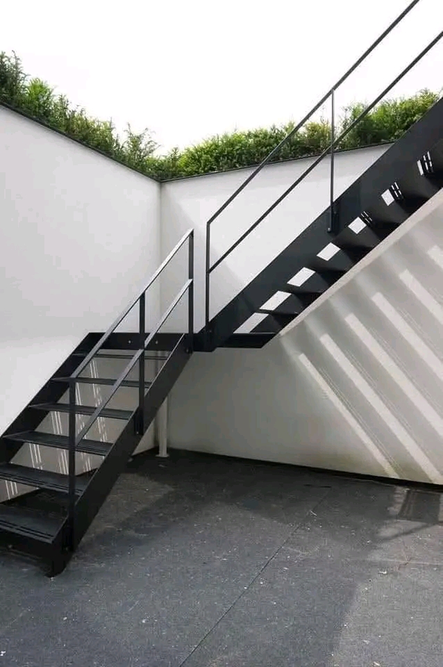 Black steel exterior staircase against a white rendered wall