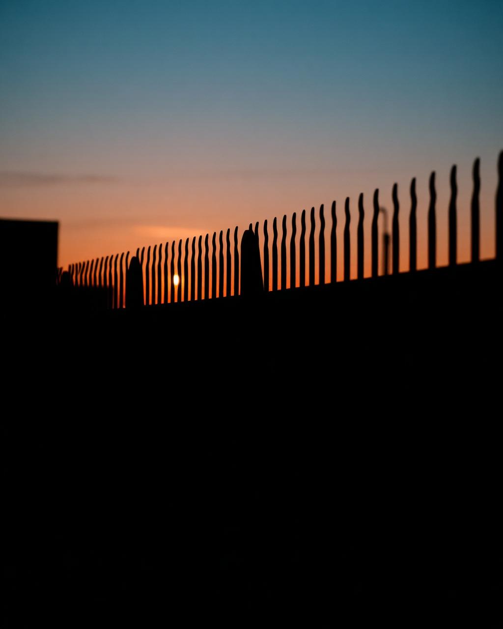 Steel palisade perimeter fencing at sunset